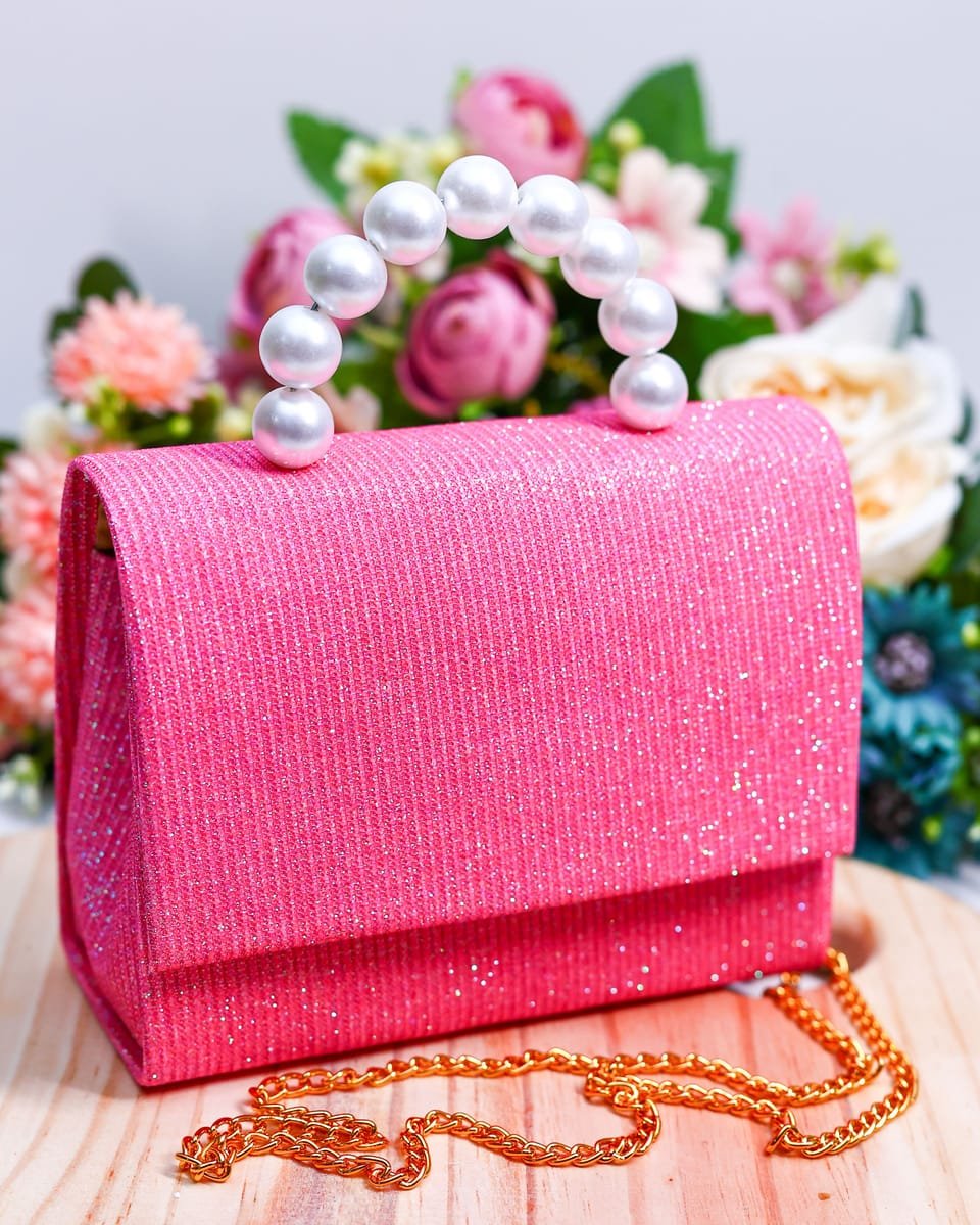 Bolsinha rosa de glitter com alça de pérolas e corrente dourada